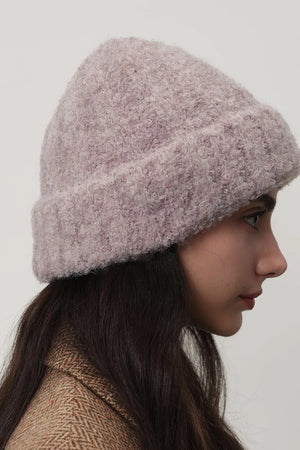 Mauve textured bouclé knit beanie with a cuffed brim, worn by a model.