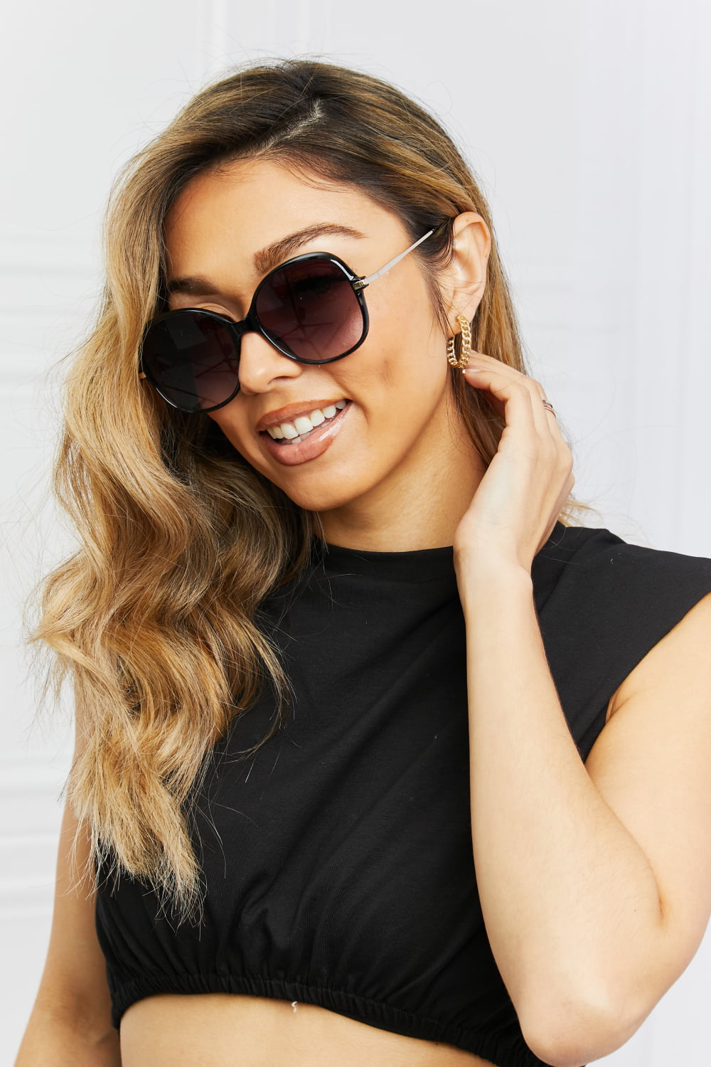 Oversized round black sunglasses with gradient lenses and gold accents.