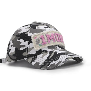 Camouflage baseball cap with distressed brim and embroidered "1MO" patch.
