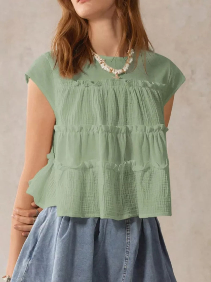 Green tiered ruffle blouse with short sleeves and textured fabric.