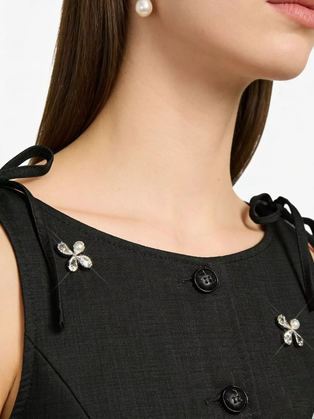 Black embellished vest with tie shoulders and floral crystal pins.