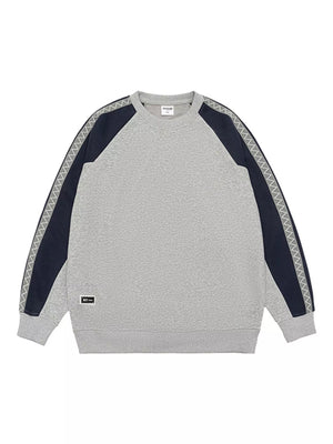 Oversized gray raglan sleeve sweatshirt with navy panels and zigzag trim detail.