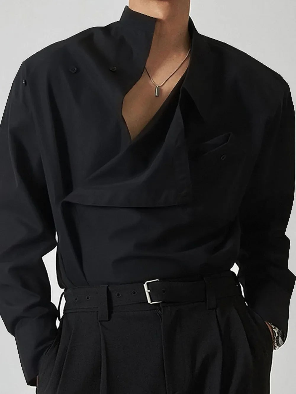 Black asymmetrical button-up shirt with architectural collar and draped detail.