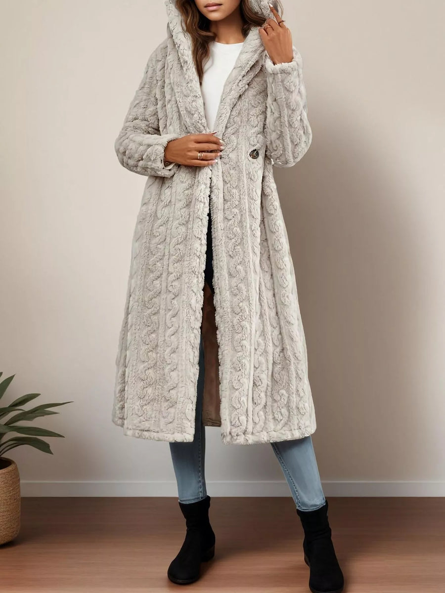Gray hooded longline coat with cable knit texture and button closure.