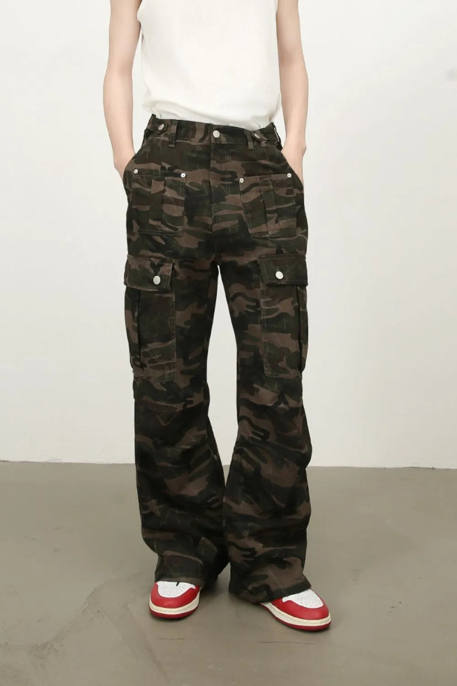 Wide-leg camo cargo trousers in green camouflage with multiple utility pockets.