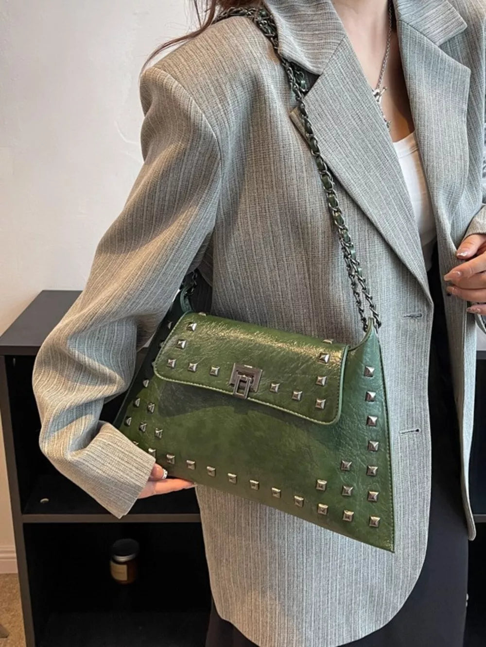 Green embellished chain flap shoulder bag with silver studs and lock closure.