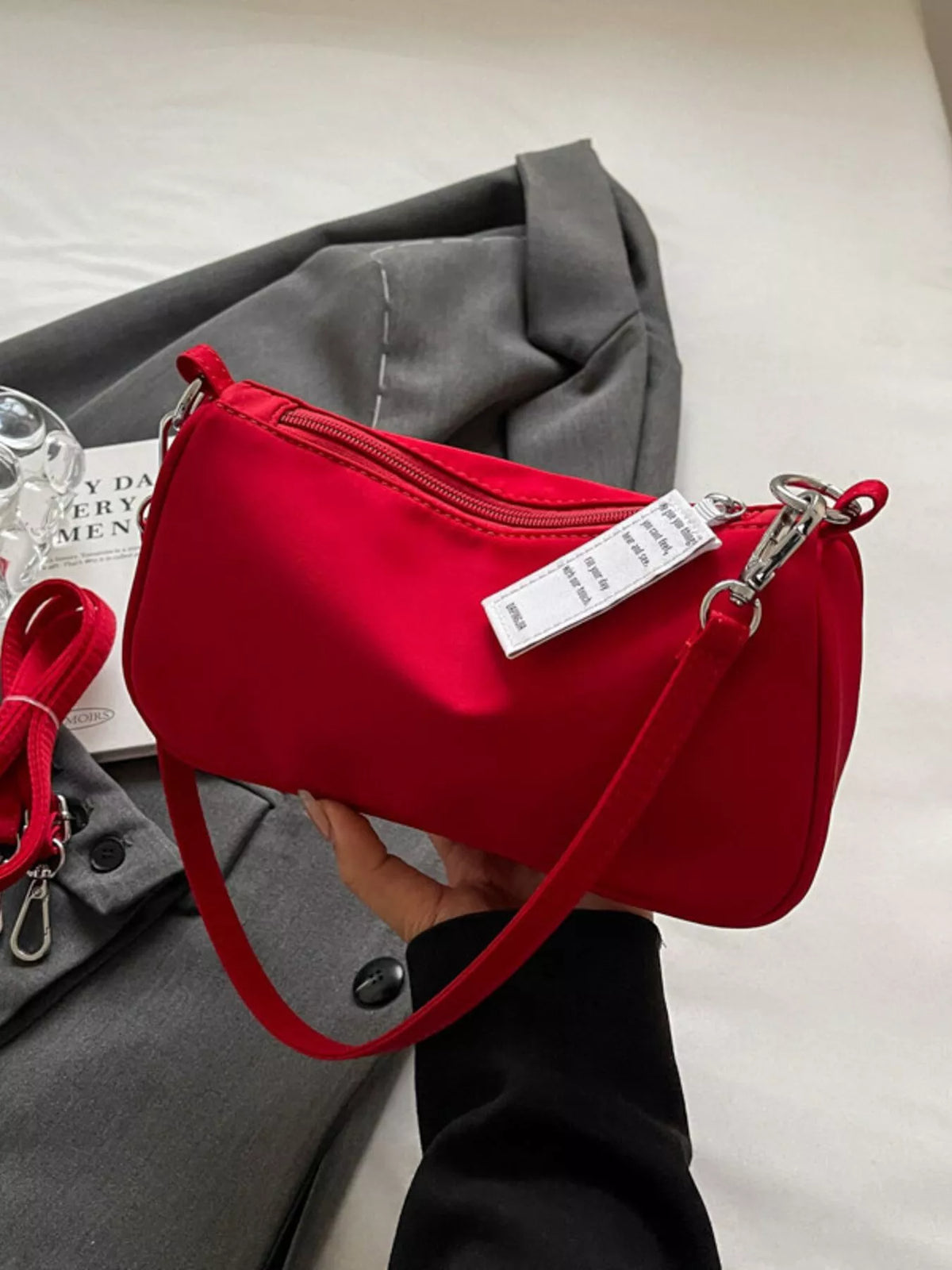 Red nylon mini crossbody bag with silver hardware and a white tag.