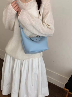 Blue mini crescent hobo bag with flap closure and adjustable strap.