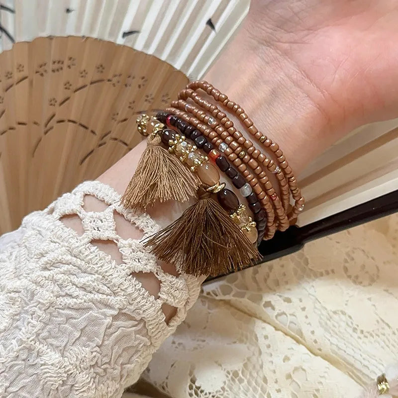 Beaded tassel stacked bracelet set in coffee brown with bronze accents and tassels.