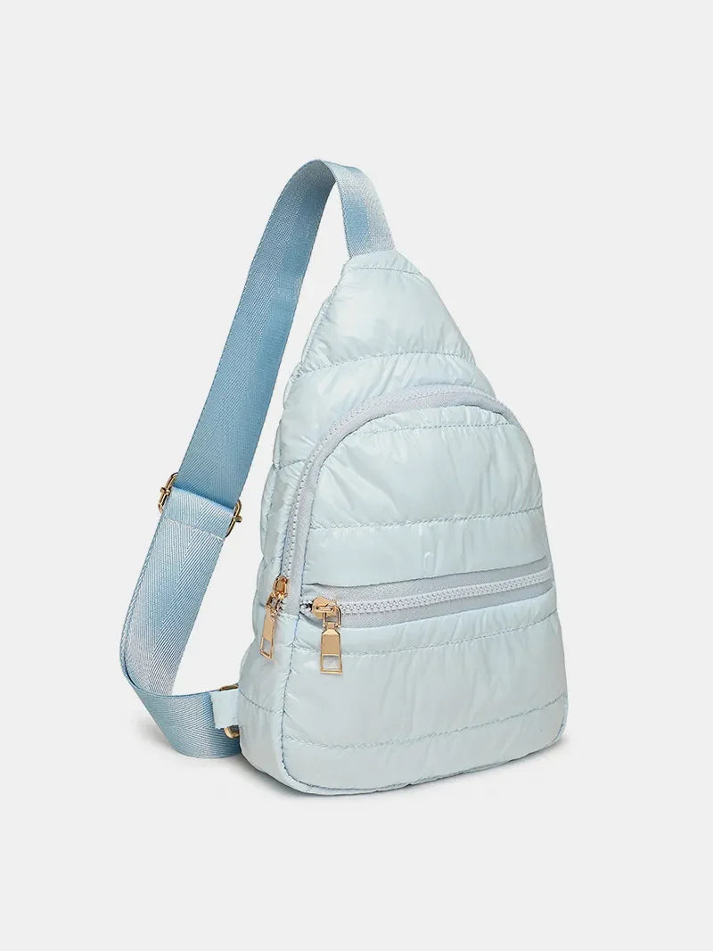 Light blue glossy padded sling bag with quilted detail and gold zippers.