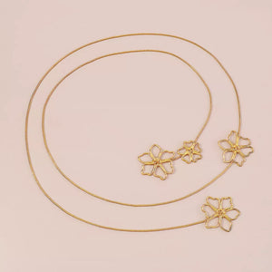 Gold necklace featuring flower pendant and floral