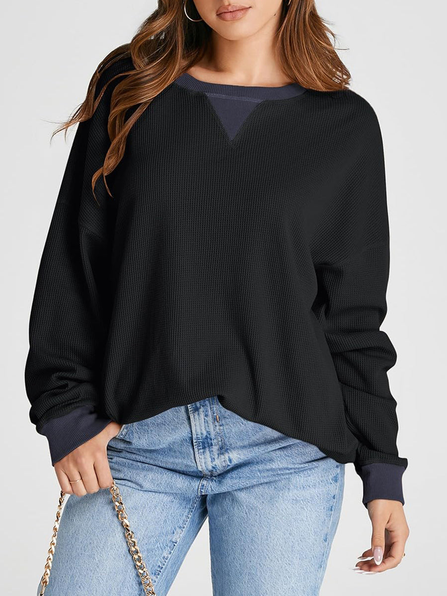 Black waffle knit raglan sleeve sweatshirt with contrast V-neck detail and navy cuffs.