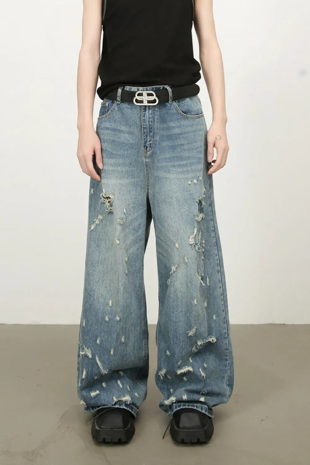 Distressed palazzo jeans in medium wash denim with raw edge detail and wide leg