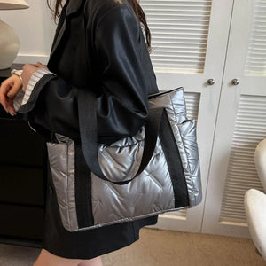 Padded nylon shopper bag in silver with exterior pockets and black straps.