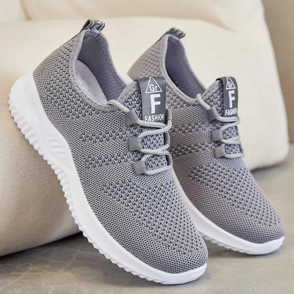 Gray breathable knit runner sneakers with logo detail and white soles.