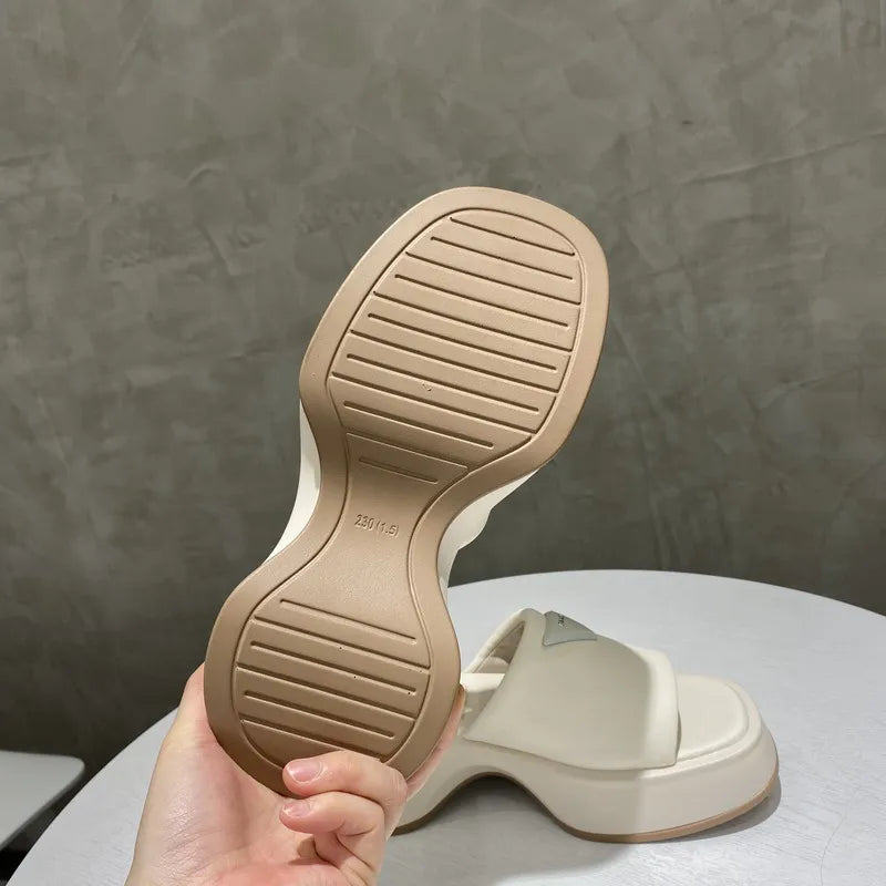 Ivory platform slides with geometric sole detail and branding.