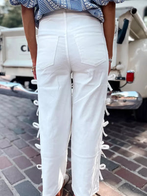 White cotton wide-leg maternity trousers with bow embellishments on the side seams.