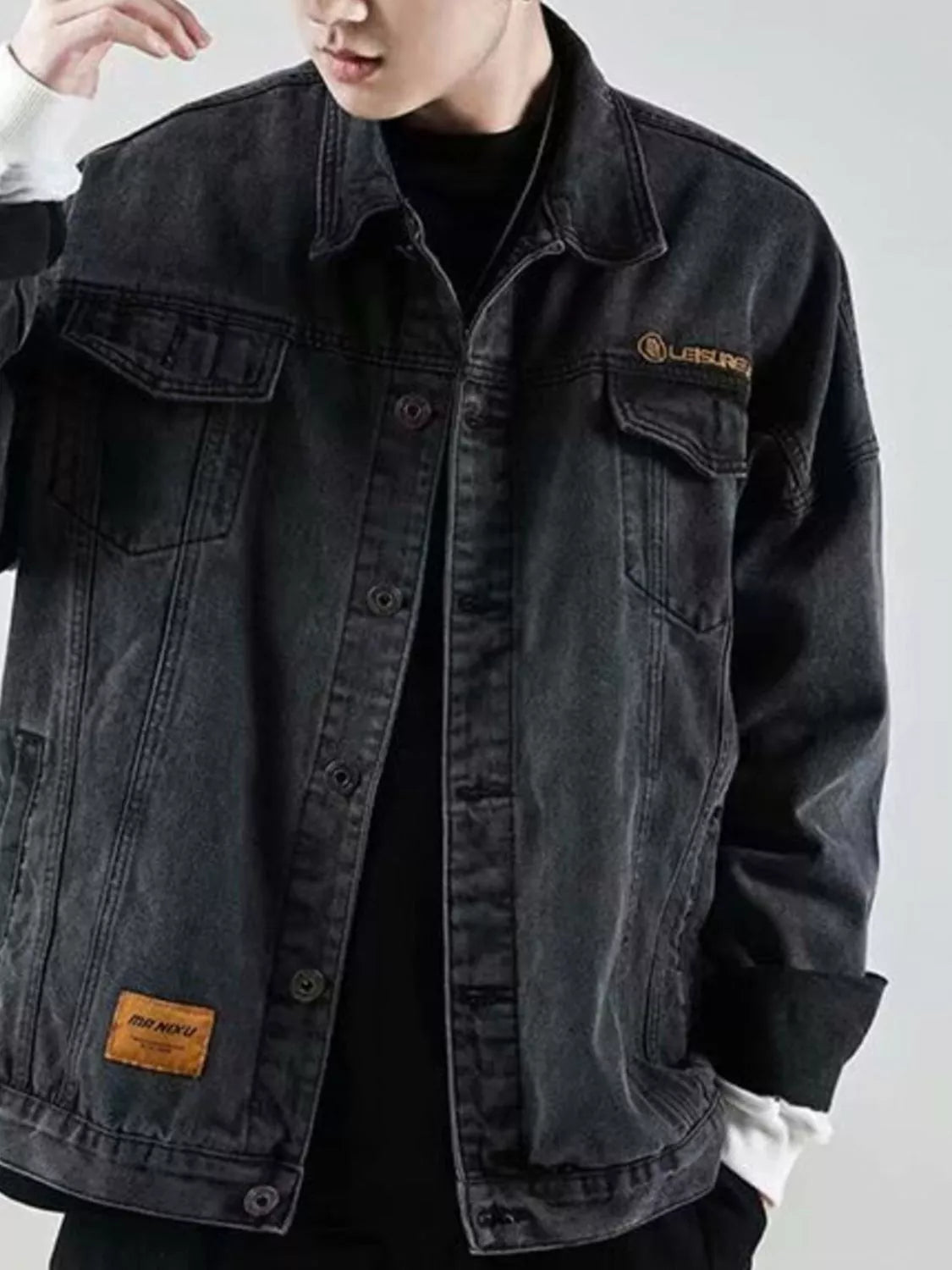 Men's black denim trucker jacket with button-up front and chest pockets.