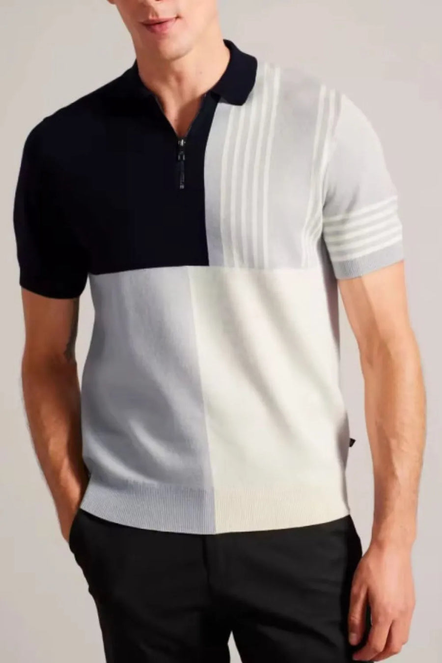 Geometric knit polo with zip neck in navy, grey, and cream colorblock with vertical stripes.