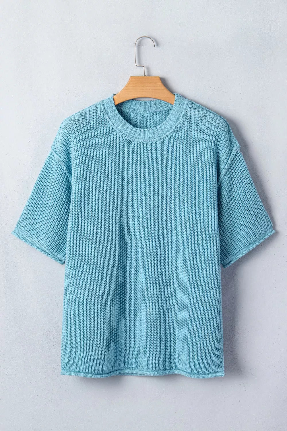 Relaxed ribbed knit sweater top in light blue with short sleeves and crew neck.
