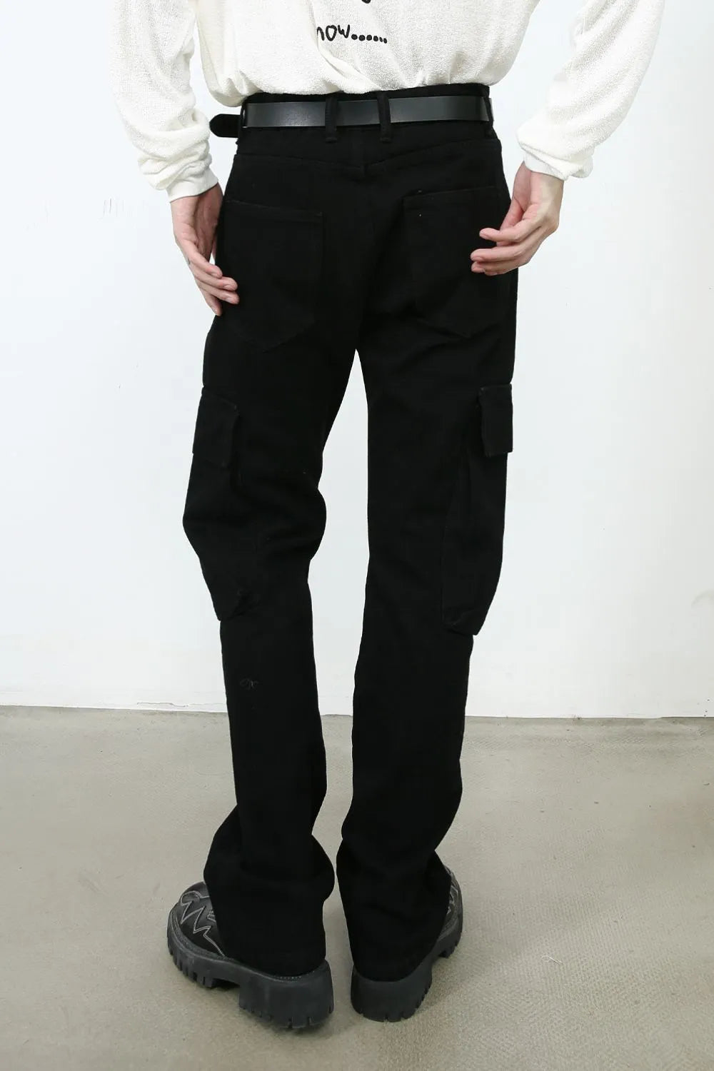 Black denim utility trousers with cargo pockets and a relaxed fit.
