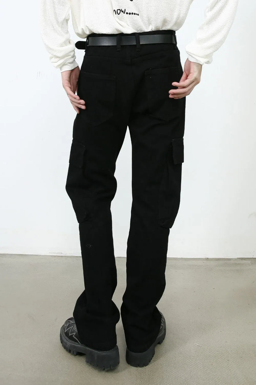 Black denim utility trousers with cargo pockets and a relaxed fit.