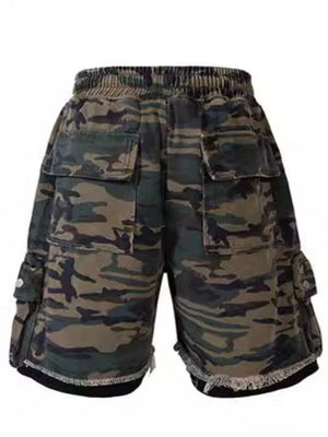 Camo cargo shorts with raw hem and multiple pockets in green camouflage pattern.
