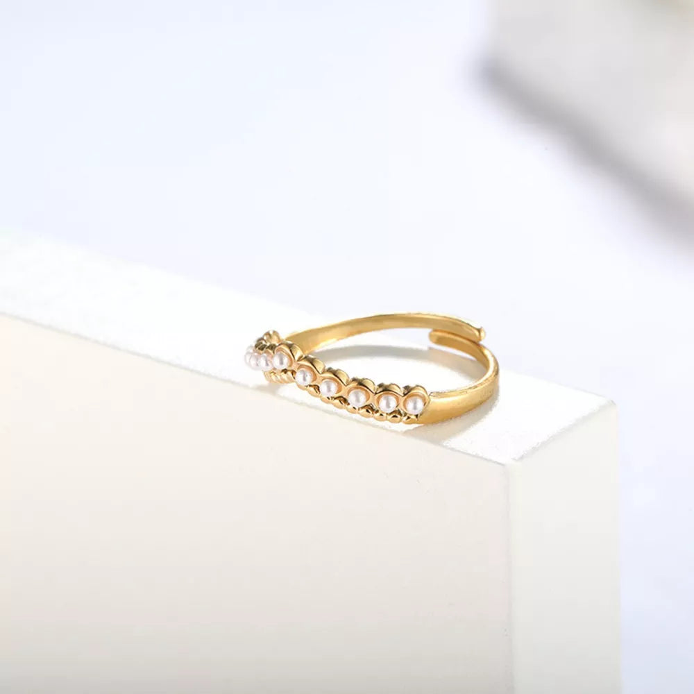 Gold adjustable ring with delicate pearl embellishments.