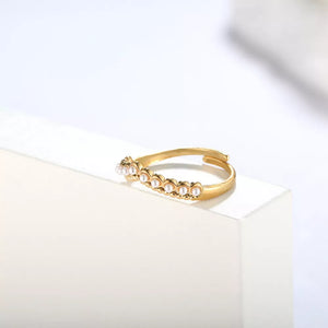 Gold adjustable ring with delicate pearl embellishments.
