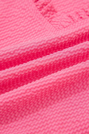 Women's pink textured embroidered blouse with a subtle diamond pattern.