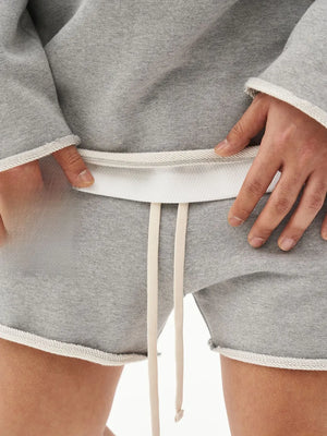 Gray fleece lounge shorts with raw edge hem and drawstring.