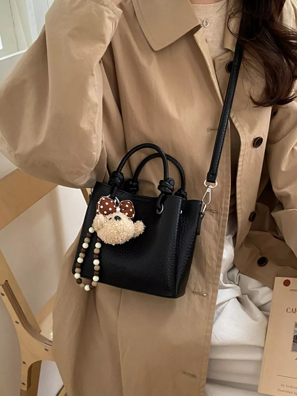 crossbody bag in black featuring top handles and structured fit