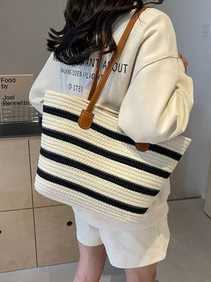black tote featuring shoulder strap and striped