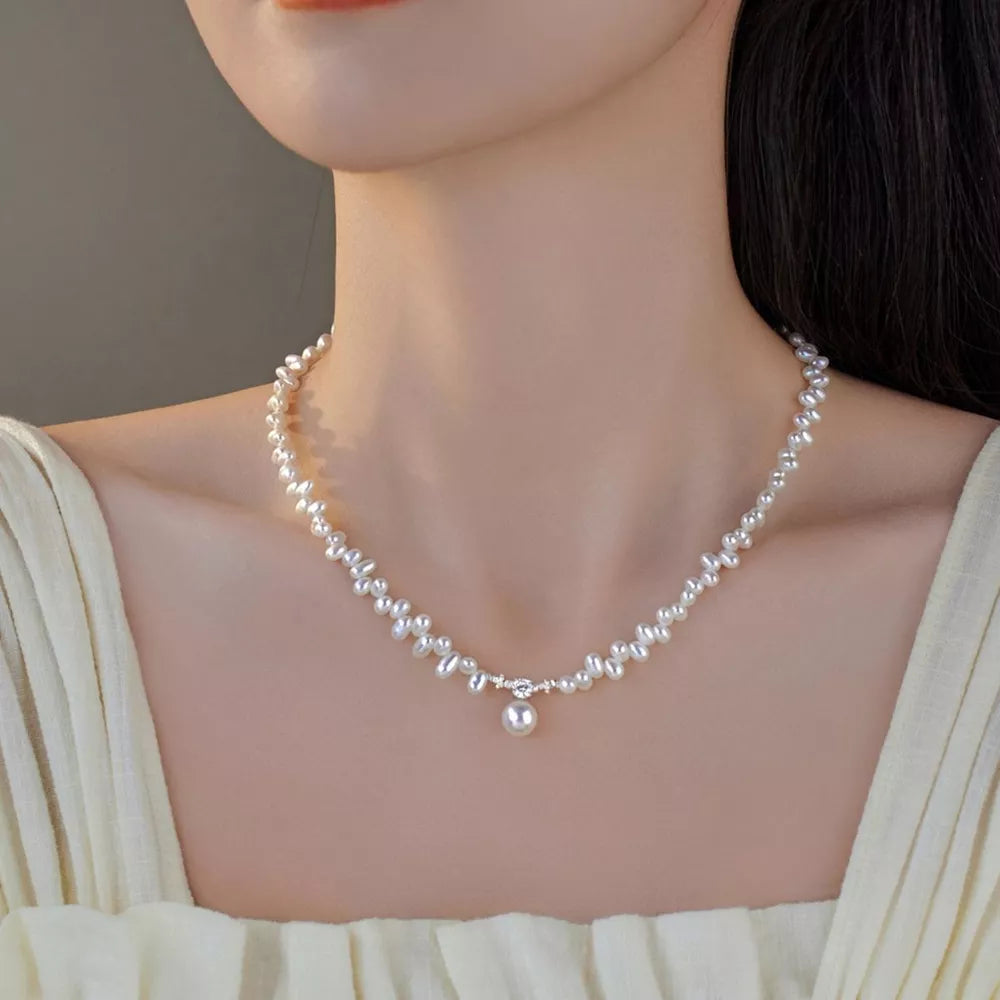 Lustrous irregular pearl pendant necklace with delicate chain and single pearl drop.