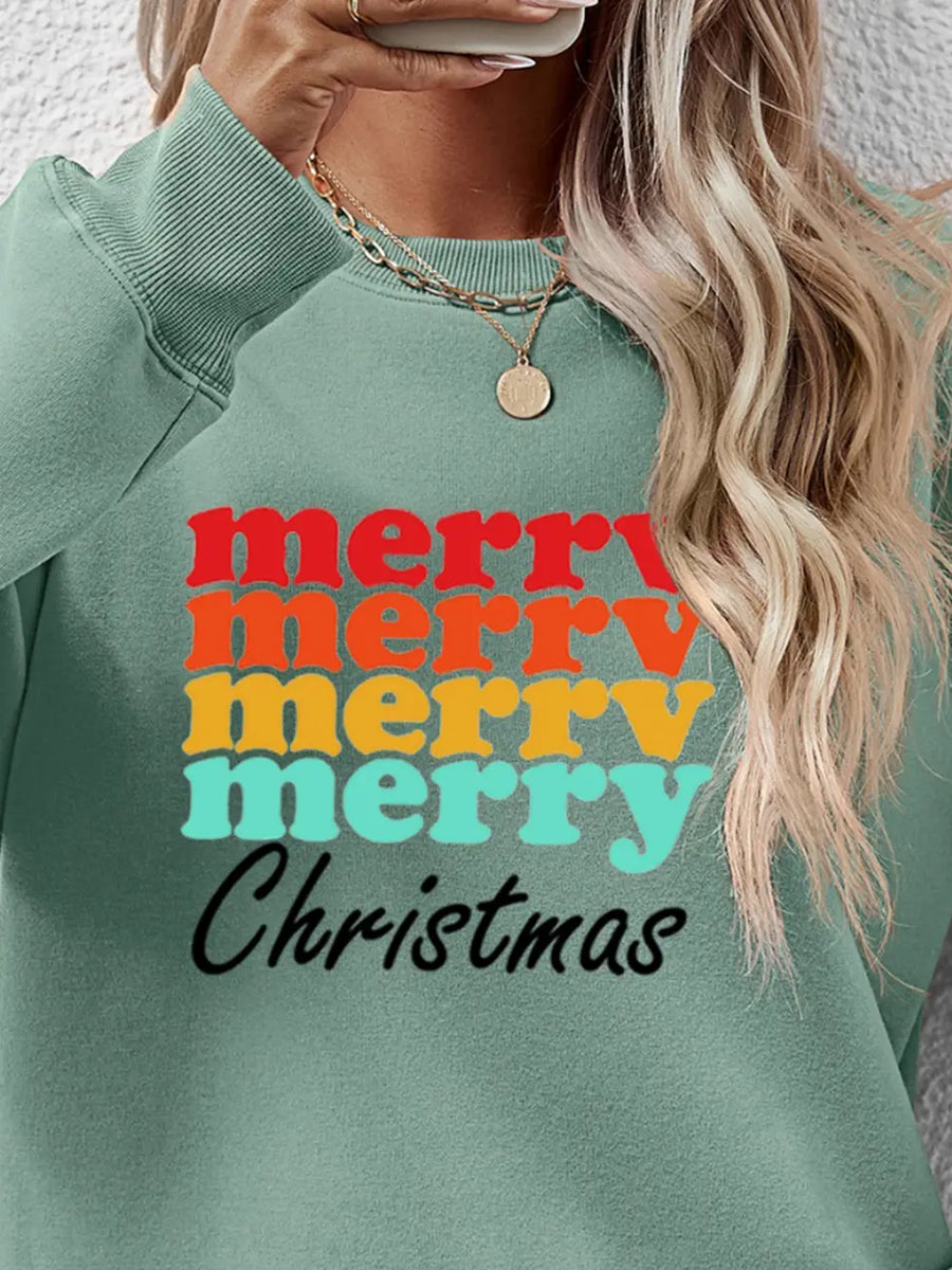 Sage green crewneck sweatshirt with retro "Merry Christmas" graphic in red, orange, yellow, and teal.