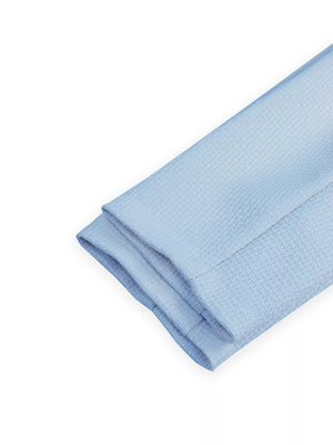 Light blue waffle knit fabric folded with a clean hem detail.