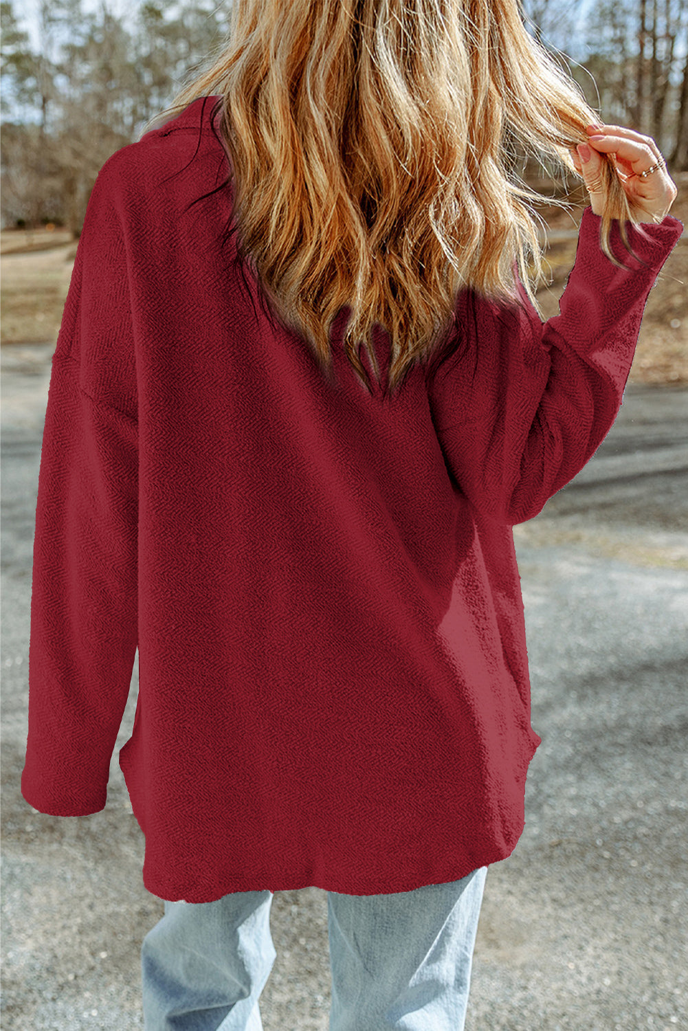 Red button-up coat with textured fabric and casual fit.