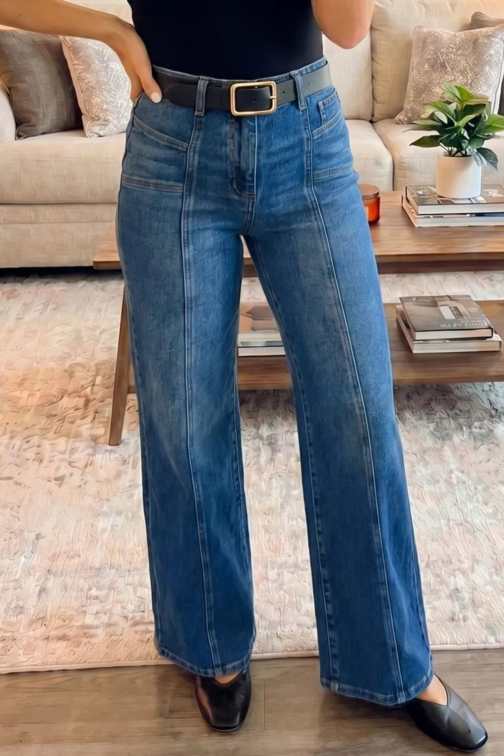 Seam-detail high-waisted wide-leg jeans in blue denim with a black belt.