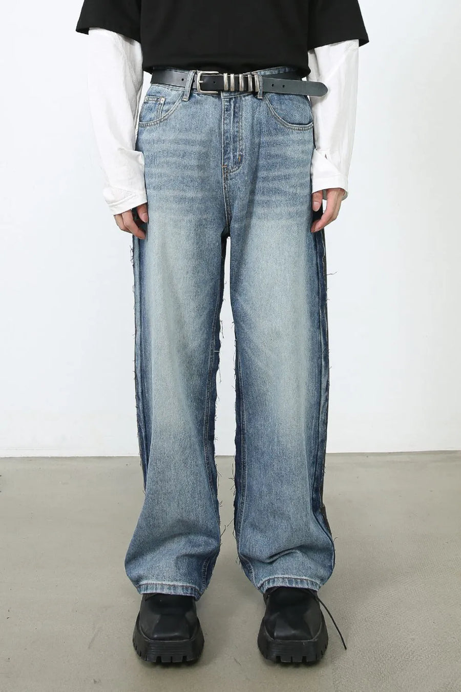Paneled wide-leg denim trousers in medium wash with distressed side seams and a relaxed fit.