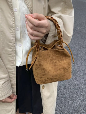 Brown suede mini crossbody bag with braided handle and drawstring closure