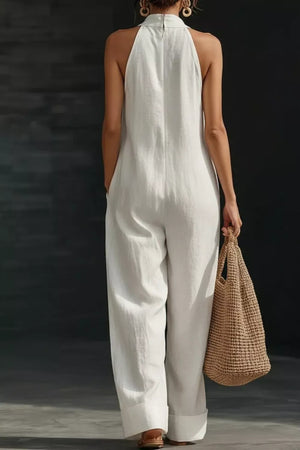 White halter-neck pocketed maternity jumpsuit with wide legs.