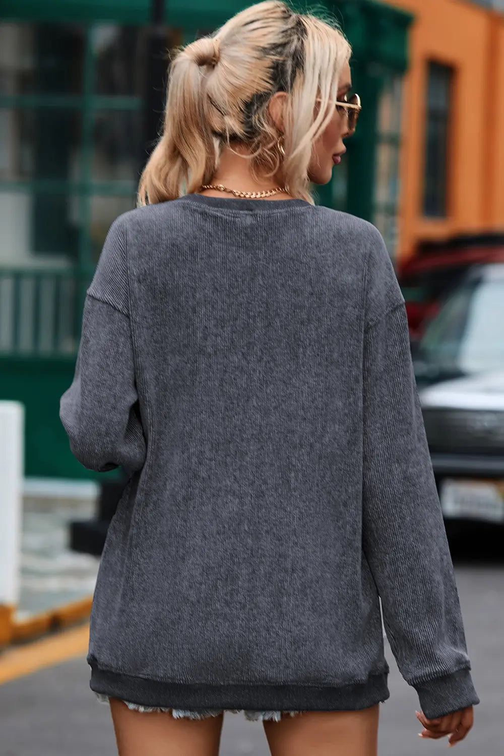 Dark gray ribbed sweatshirt with crew neck and long sleeves.