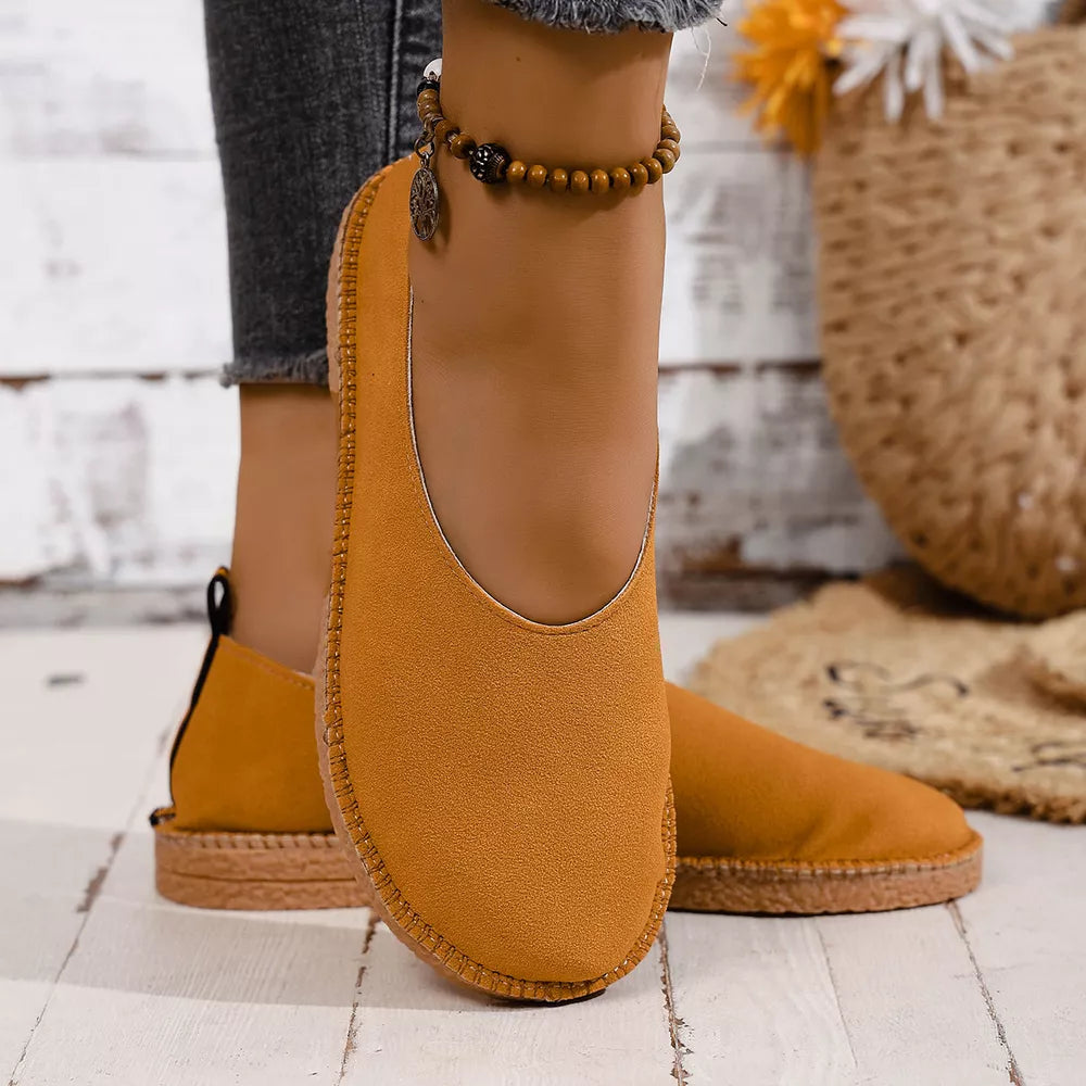 Yellow espadrille-inspired slip-on flats with round toe and stitched sole detail.