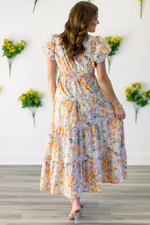 Vibrant floral smocked maxi dress with tiered skirt and short puff sleeves.