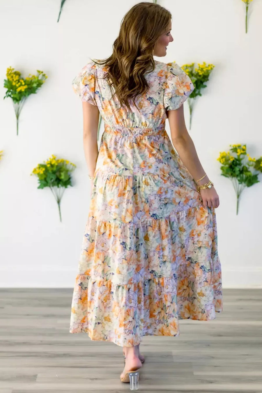 Vibrant floral smocked maxi dress with tiered skirt and short puff sleeves.