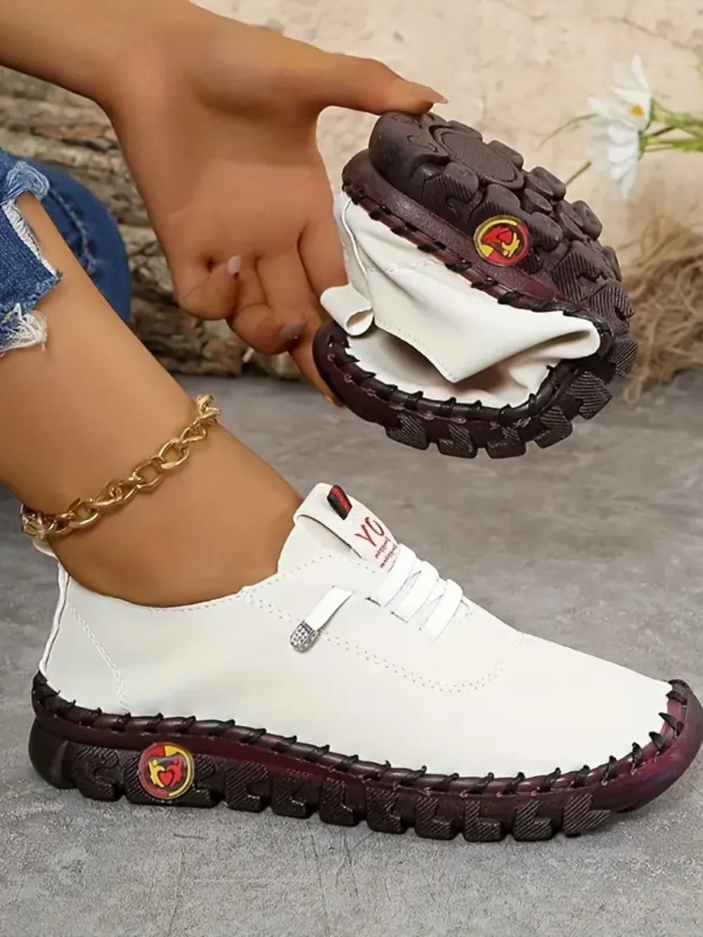 White faux leather loafers with contrast stitching and a flexible sole.