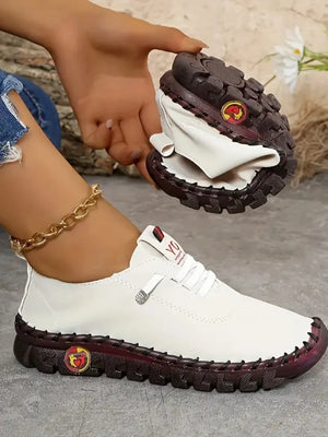 White faux leather loafers with contrast stitching and a flexible sole.