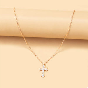 Gold rhinestone cross pendant necklace with a delicate chain.