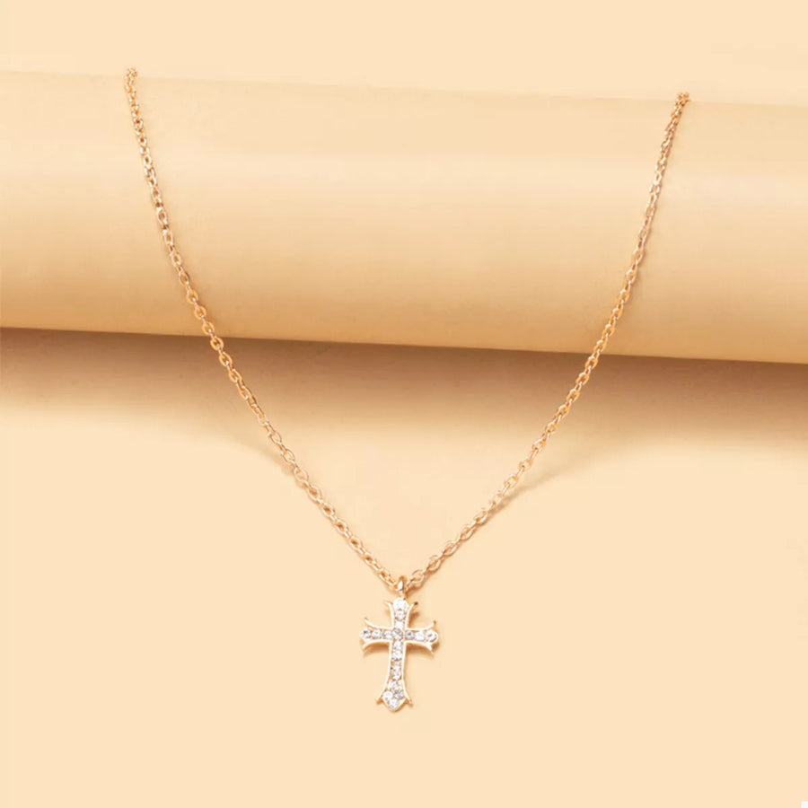 Gold rhinestone cross pendant necklace with a delicate chain.