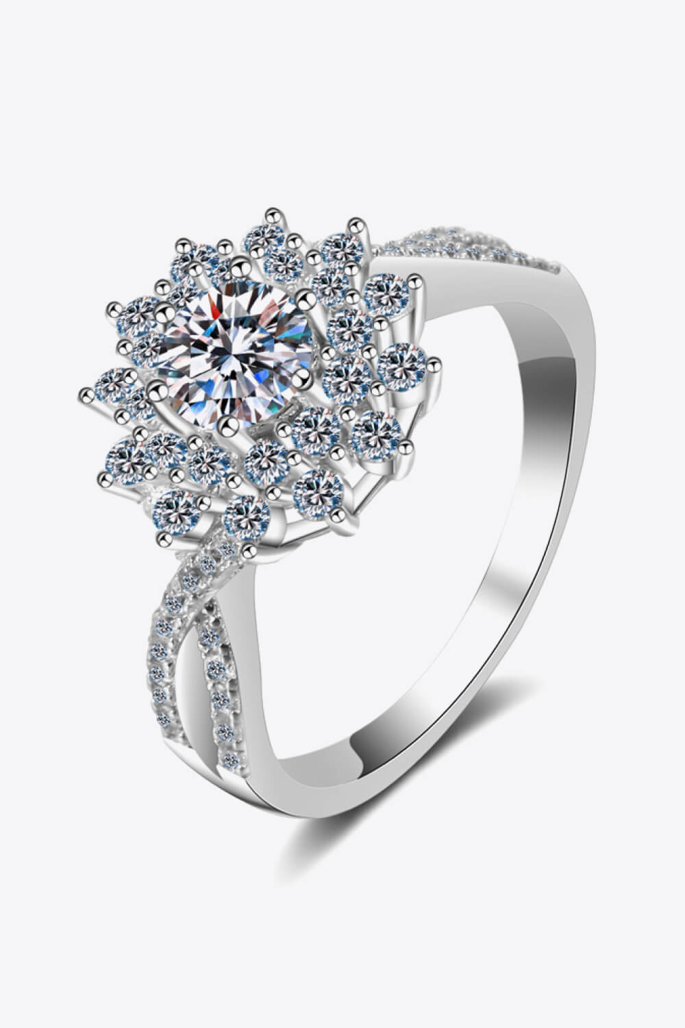 Silver moissanite halo ring with a floral-inspired design and twisted band.